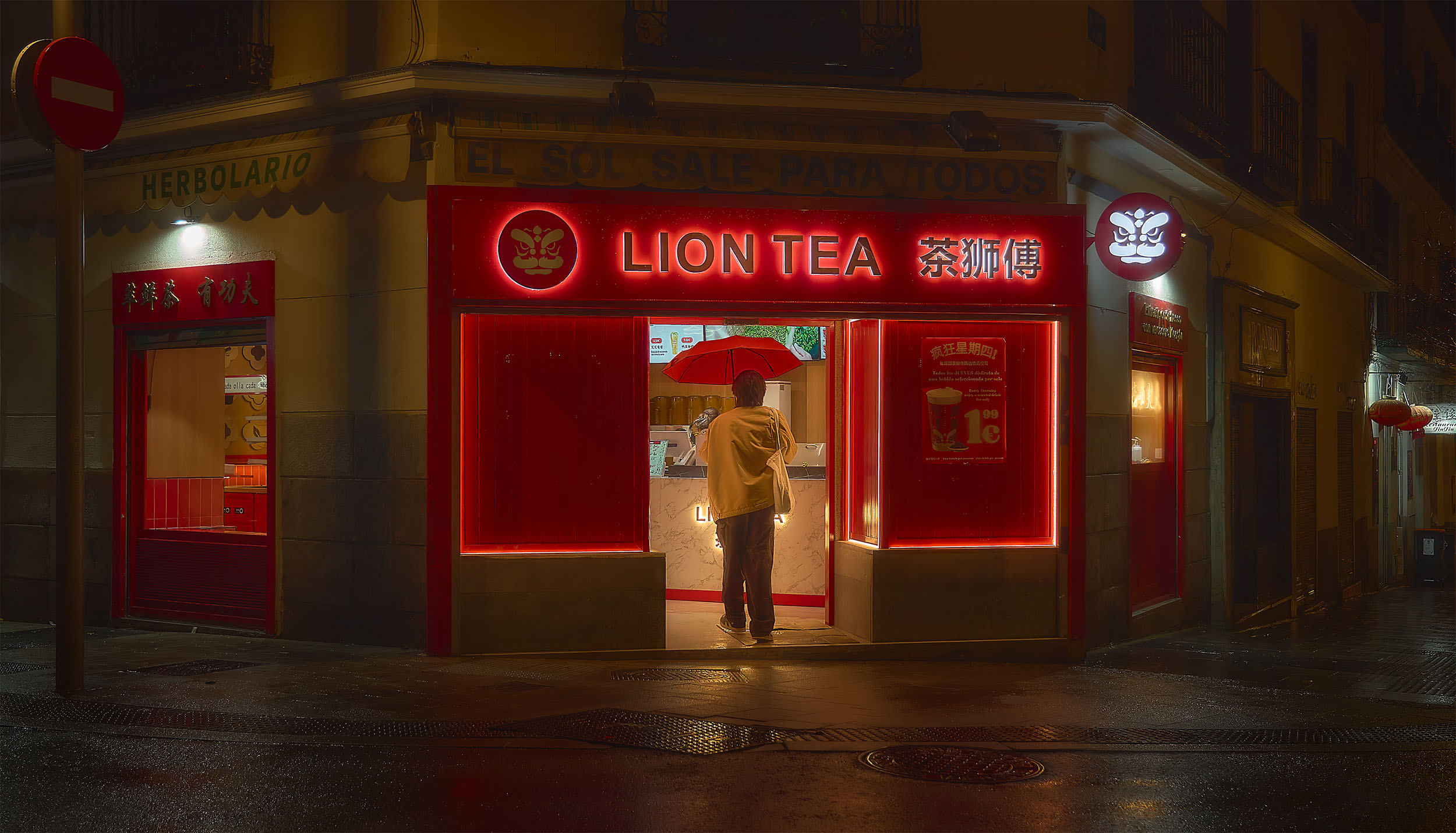 Person with red umbrella standing at the entrance of Lion Tea shop at night, intense red neon light reflecting on wet Madrid street