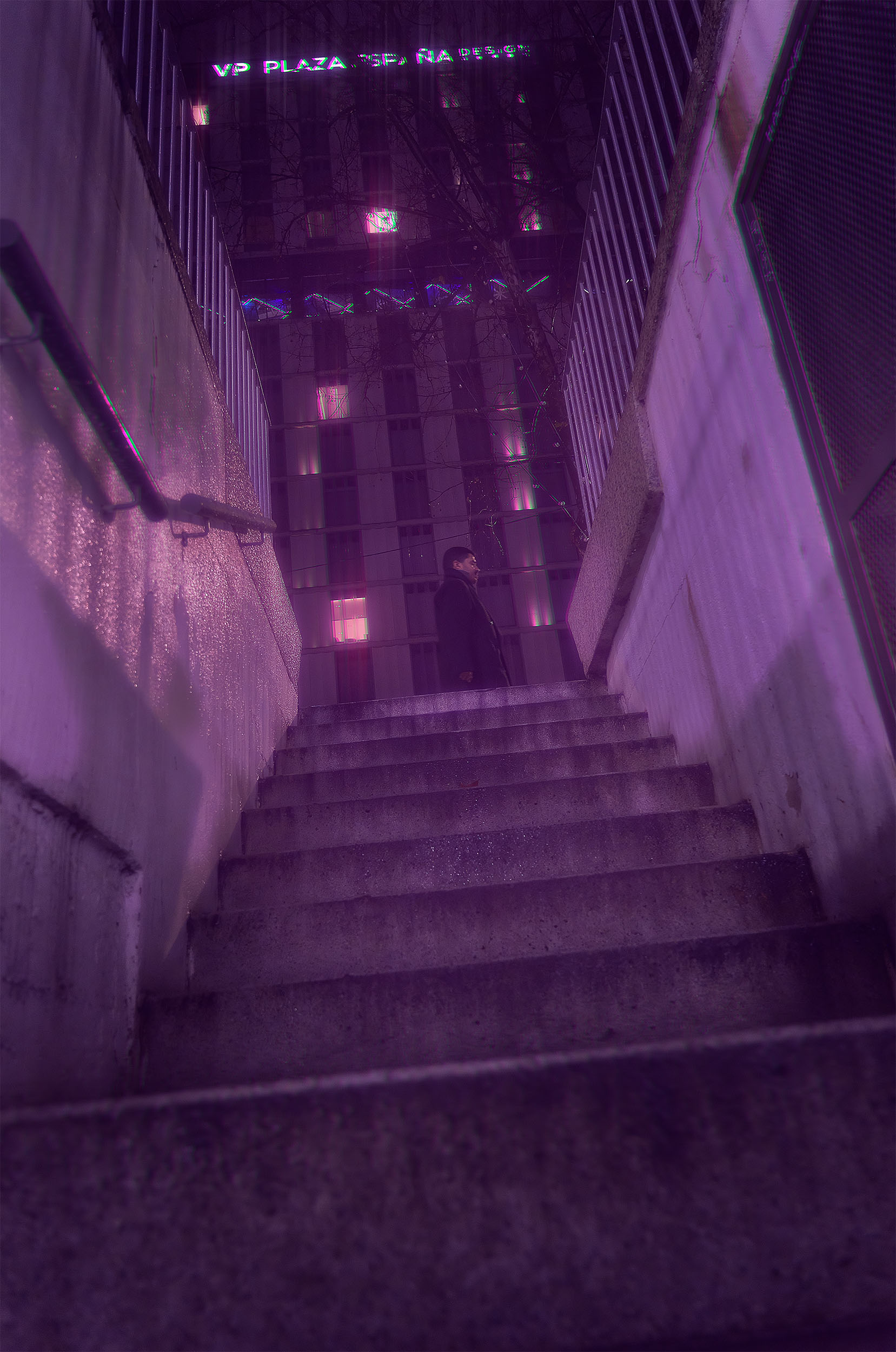 Lone figure at the top of concrete stairs at night in Madrid, VP Plaza España Design sign glowing above, purple atmospheric haze, cyberpunk street photography