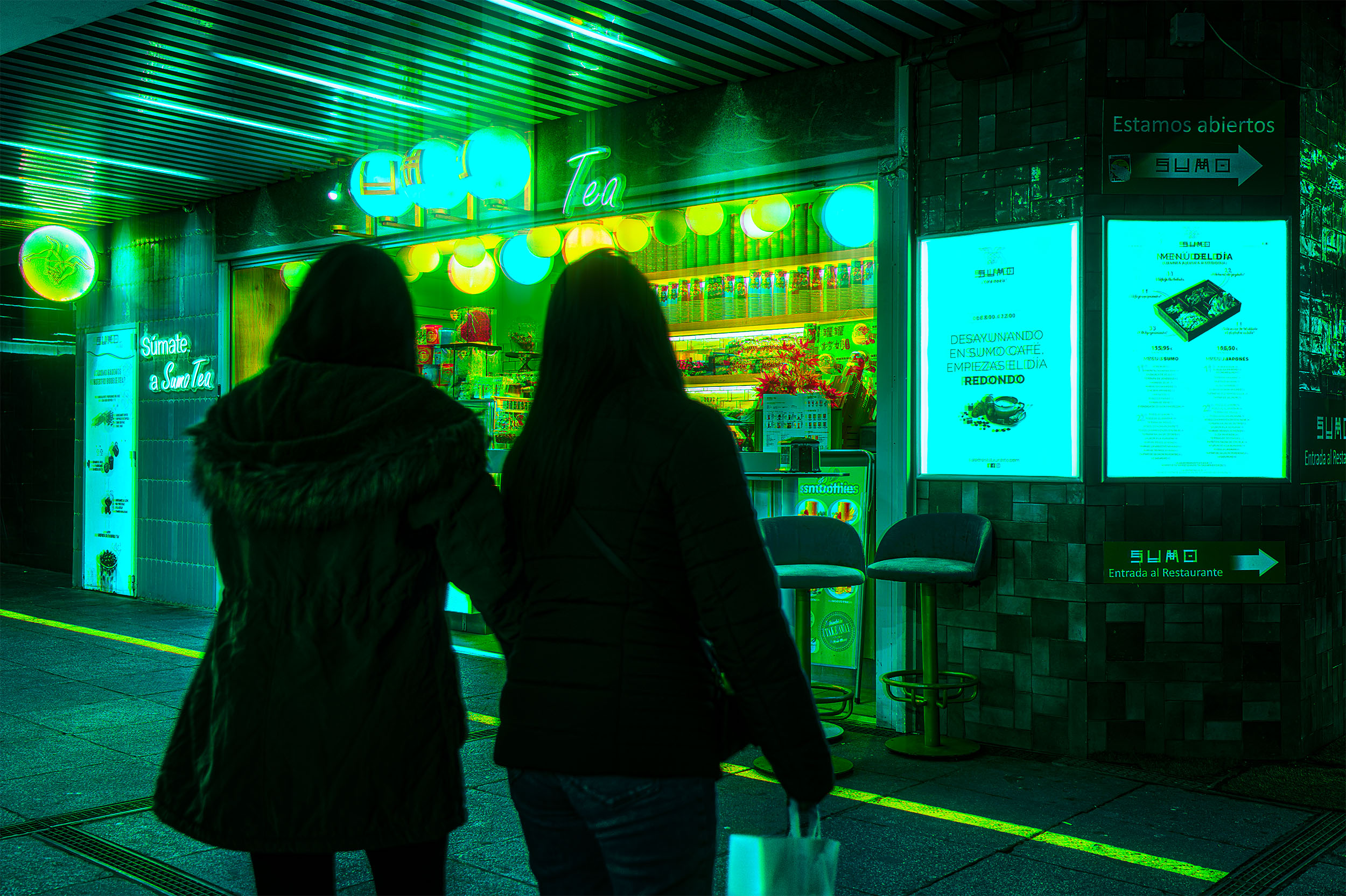 Two silhouettes walking towards Sumo Tea, a glowing green tea shop at night in Madrid, Spain, neon lanterns and illuminated signage, cyberpunk atmosphere