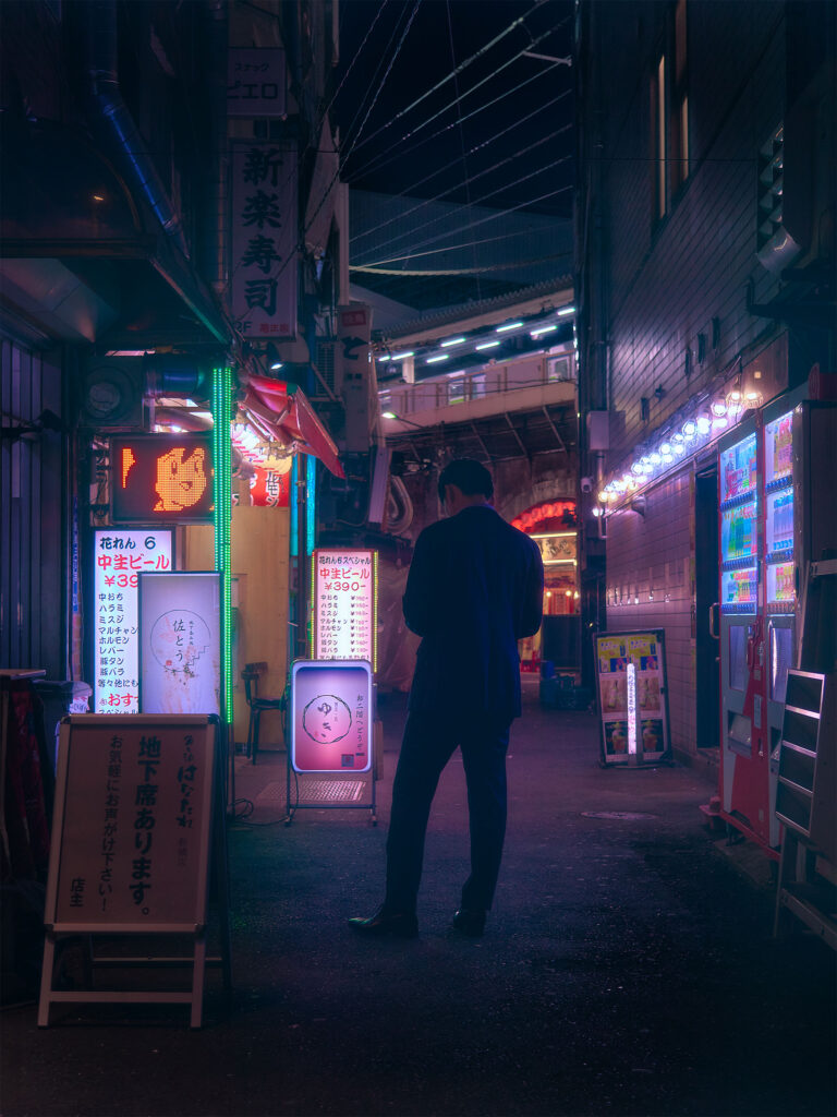Lone figure pausing on a street at night in Shimbashi, Tokyo, Japan, warm neon light from surrounding shops, cyberpunk street photography