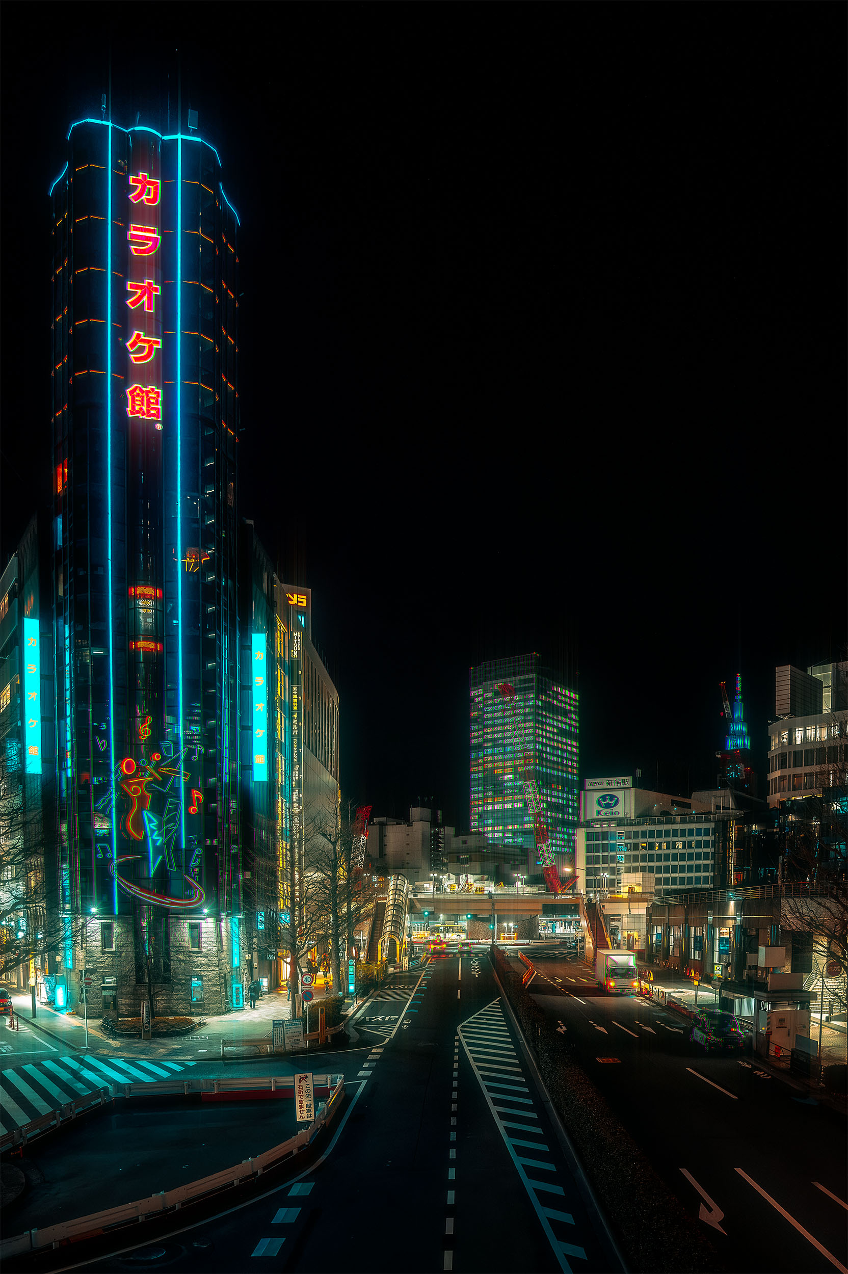 Karaoke-kan tower lit by cyan and red neon signs above an empty street in Shinjuku, Tokyo, Japan, seen from a pedestrian bridge at night, cyberpunk atmosphere