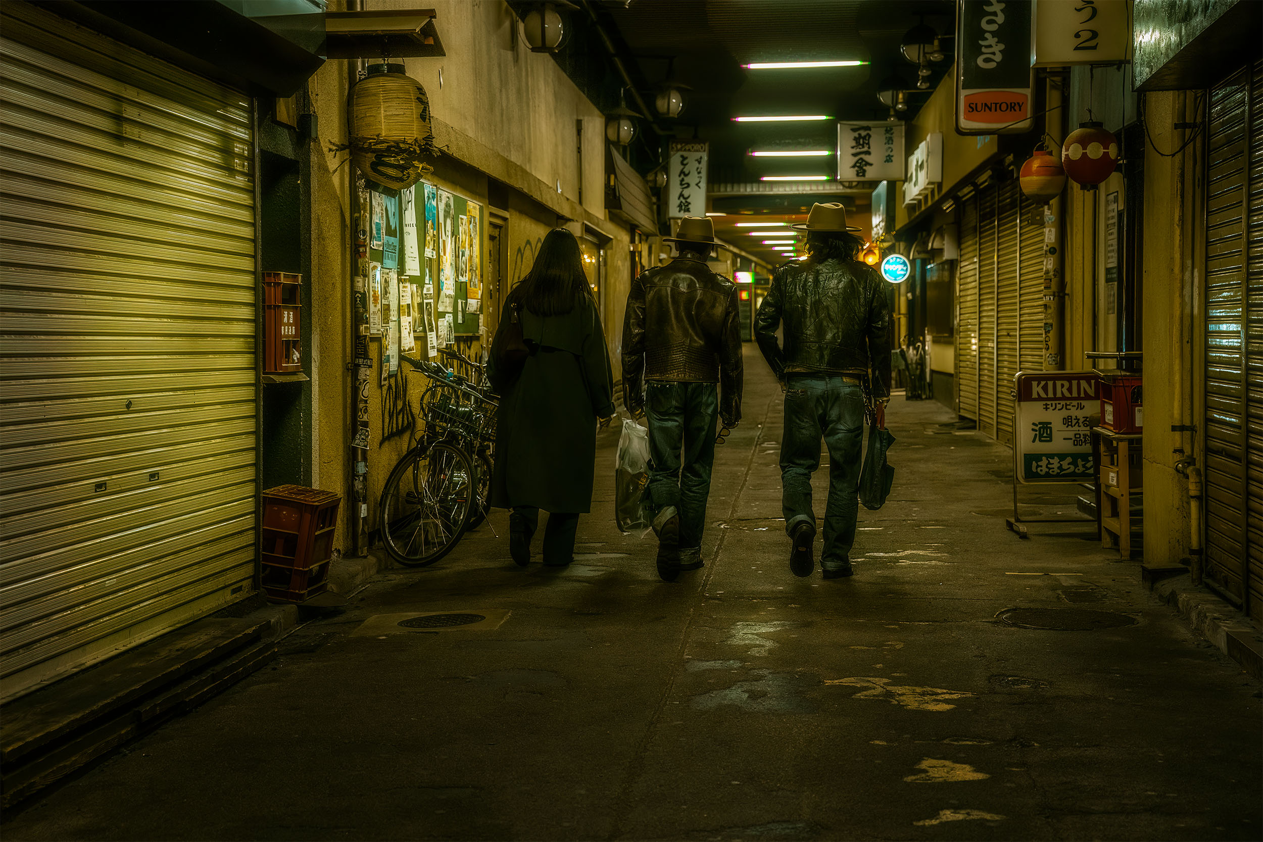 Three figures walking through a shotengai shopping arcade at night in Tokyo, Japan, closed metal shutters and hanging lanterns lining the street, cyberpunk atmosphere